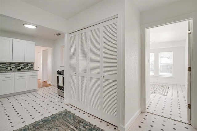 kitchen featuring decorative backsplash, baseboards, light floors, white cabinetry, and recessed lighting