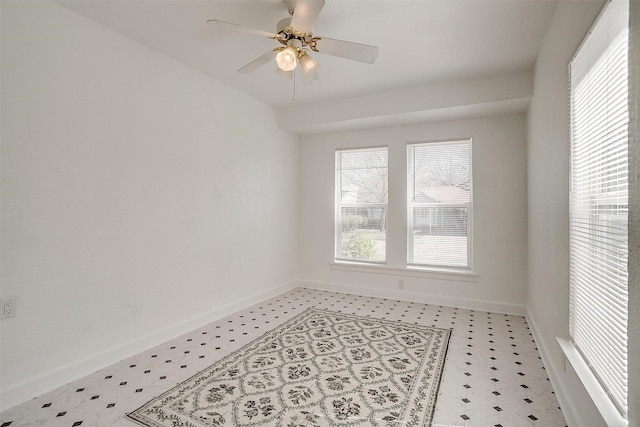 empty room featuring light flooring, baseboards, and a ceiling fan