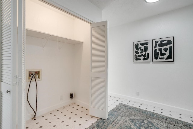 laundry area with washer hookup, light floors, and baseboards