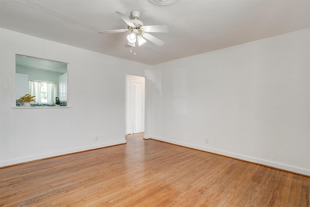 empty room with light wood finished floors, baseboards, and ceiling fan