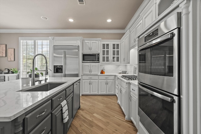7208 Majestic Mnr, Colleyville, TX 76034 - kitchen with appliances with stainless steel finishes, a sink, crown molding, white cabinetry, and tasteful backsplash