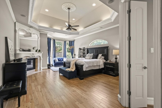 7208 Majestic Mnr, Colleyville, TX 76034 - bedroom with a raised ceiling, crown molding, a glass covered fireplace, access to exterior, and light wood-type flooring