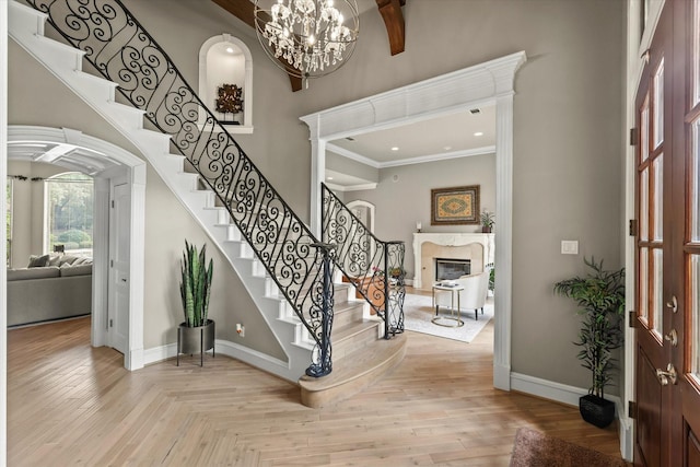 7208 Majestic Mnr, Colleyville, TX 76034 - foyer with baseboards, a fireplace, stairs, a chandelier, and ornamental molding