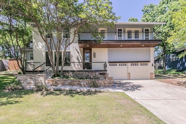 view of front of property featuring a balcony, an attached garage, driveway, and a porch