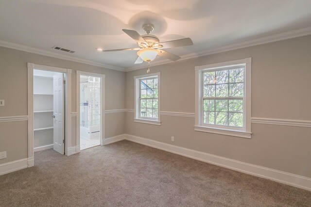 unfurnished bedroom featuring carpet flooring, baseboards, crown molding, a ceiling fan, and ensuite bathroom