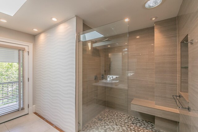 bathroom with tiled shower, recessed lighting, a skylight, and tile patterned flooring