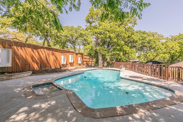 view of swimming pool with a fenced backyard, a pool with connected hot tub, and a patio area
