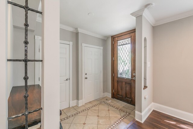 entrance foyer with crown molding and baseboards