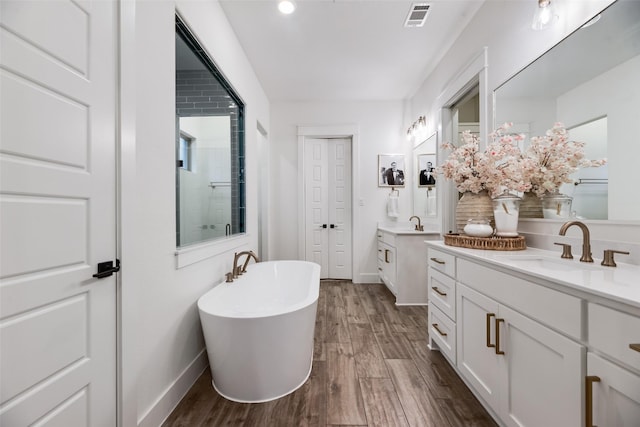 2218 Somercrest Pl, Midlothian, TX 76065 - full bath featuring two vanities, baseboards, a freestanding bath, wood finished floors, and a stall shower