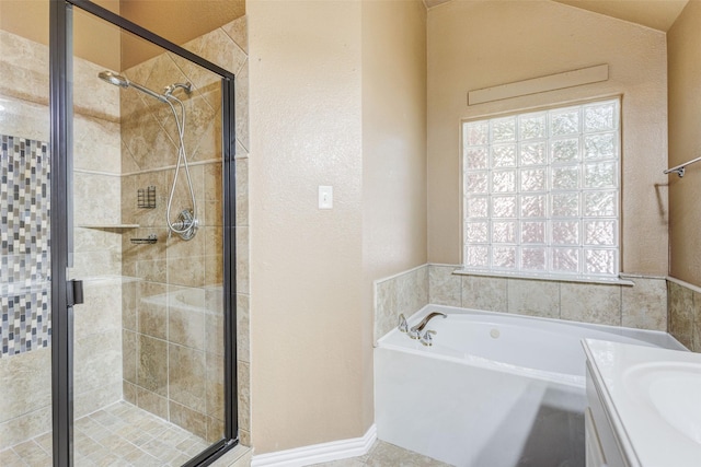 full bathroom with a stall shower, a garden tub, vanity, and a textured wall