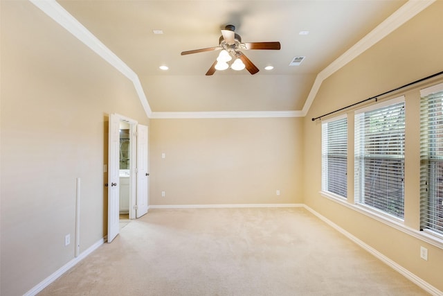 spare room with vaulted ceiling, ceiling fan, baseboards, crown molding, and light colored carpet