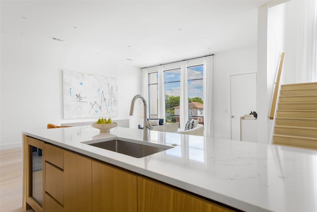 610 N Oak Cliff Blvd Unit 205, Dallas, TX 75208 - kitchen with a sink, light stone countertops, modern cabinets, light wood-style flooring, and wine cooler