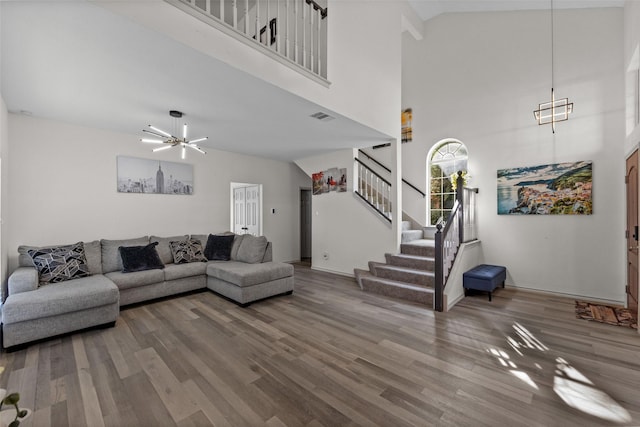 2410 Hedgeway Cir, Garland, TX 75044 - living room featuring stairs, wood finished floors, high vaulted ceiling, a chandelier, and baseboards
