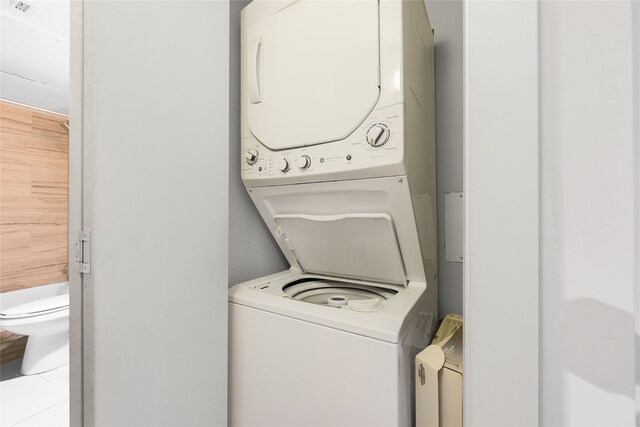 clothes washing area with stacked washer / dryer