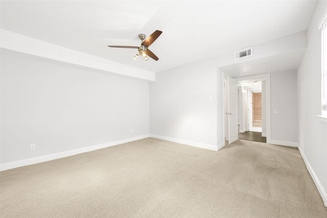 unfurnished room featuring light colored carpet, ceiling fan, and baseboards