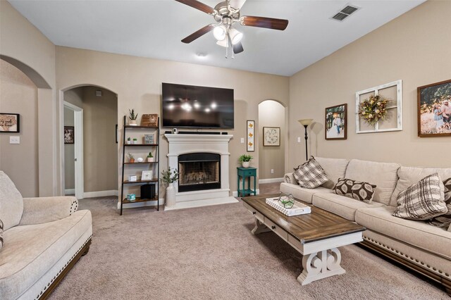 1461 Lakeview Dr, Pelican Bay, TX 76020 - carpeted living area with ceiling fan, arched walkways, a fireplace with raised hearth, and baseboards