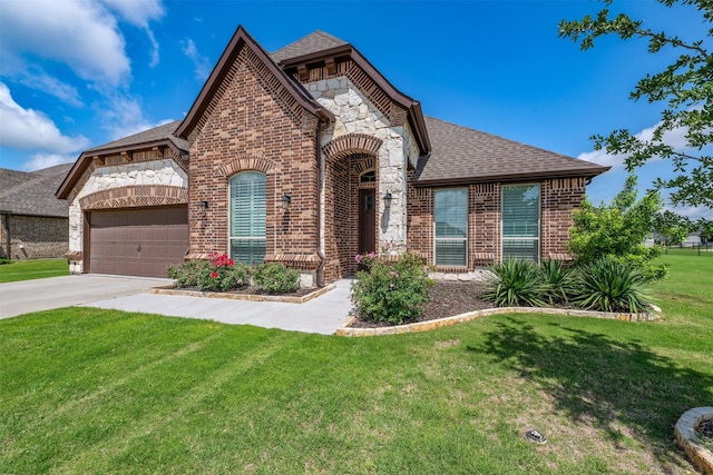 french country home with brick siding, concrete driveway, a front lawn, roof with shingles, and a garage