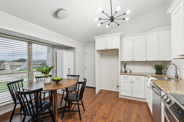 7116 Independence Dr, The Colony, TX 75056 - kitchen with stainless steel appliances, vaulted ceiling, backsplash, light stone counters, and a chandelier