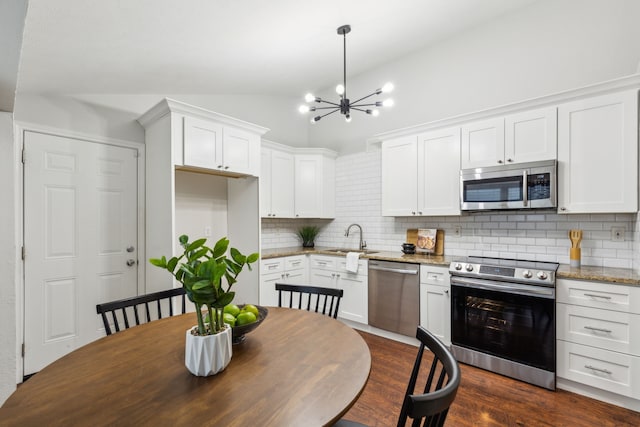 7116 Independence Dr, The Colony, TX 75056 - kitchen with appliances with stainless steel finishes, a sink, white cabinets, backsplash, and lofted ceiling