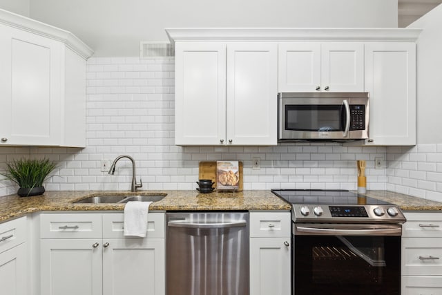 7116 Independence Dr, The Colony, TX 75056 - kitchen featuring appliances with stainless steel finishes, a sink, backsplash, and white cabinets