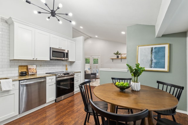 7116 Independence Dr, The Colony, TX 75056 - kitchen with appliances with stainless steel finishes, backsplash, white cabinets, vaulted ceiling, and dark wood-type flooring