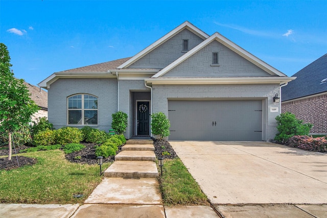 view of front of home with an attached garage, brick siding, and driveway