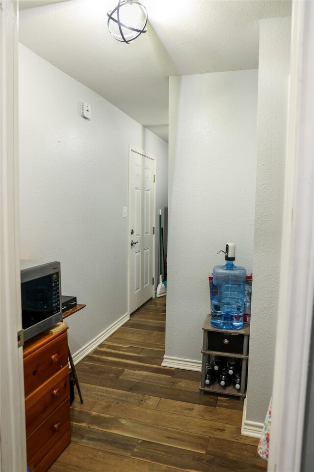 corridor featuring hardwood / wood-style flooring and baseboards