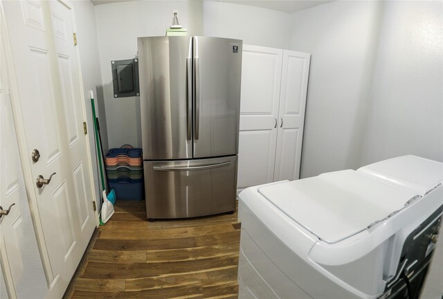 laundry room featuring cabinet space, dark wood-type flooring, washing machine and clothes dryer, and electric panel