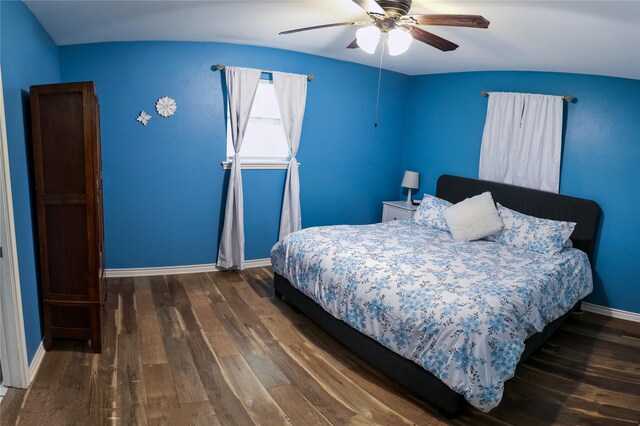 bedroom featuring dark wood-style flooring, baseboards, a ceiling fan, and vaulted ceiling