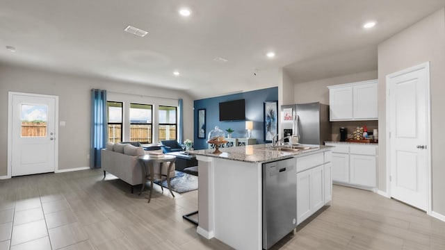 4109 Azam Ln, Fort Worth, TX 76036 - kitchen featuring stainless steel appliances, open floor plan, a sink, light stone countertops, and an island with sink