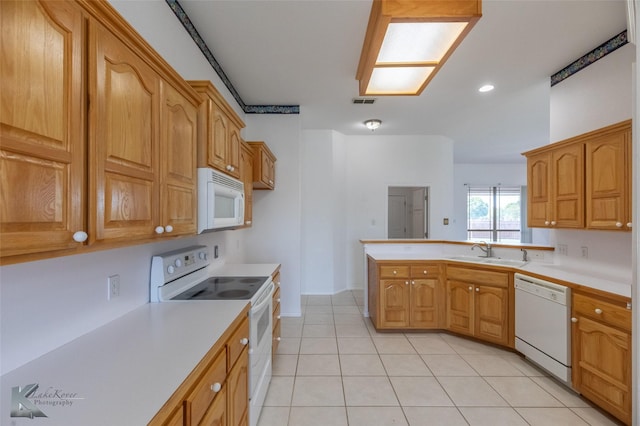 7118 Sable Cir, Abilene, TX 79606 - kitchen with white appliances, a sink, light countertops, a peninsula, and light tile patterned floors