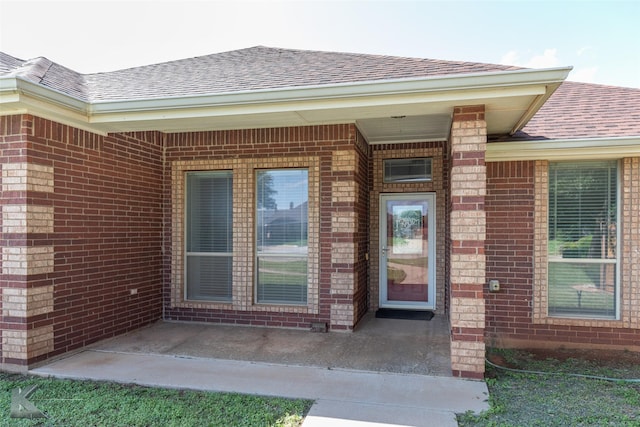 7118 Sable Cir, Abilene, TX 79606 - doorway to property featuring roof with shingles and brick siding