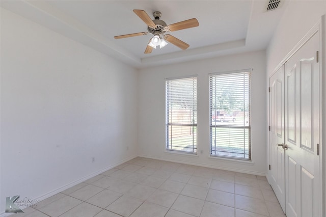 7118 Sable Cir, Abilene, TX 79606 - spare room with a tray ceiling, light tile patterned floors, ceiling fan, and baseboards