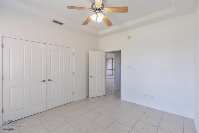 7118 Sable Cir, Abilene, TX 79606 - unfurnished bedroom featuring a raised ceiling, a closet, baseboards, a ceiling fan, and light tile patterned floors