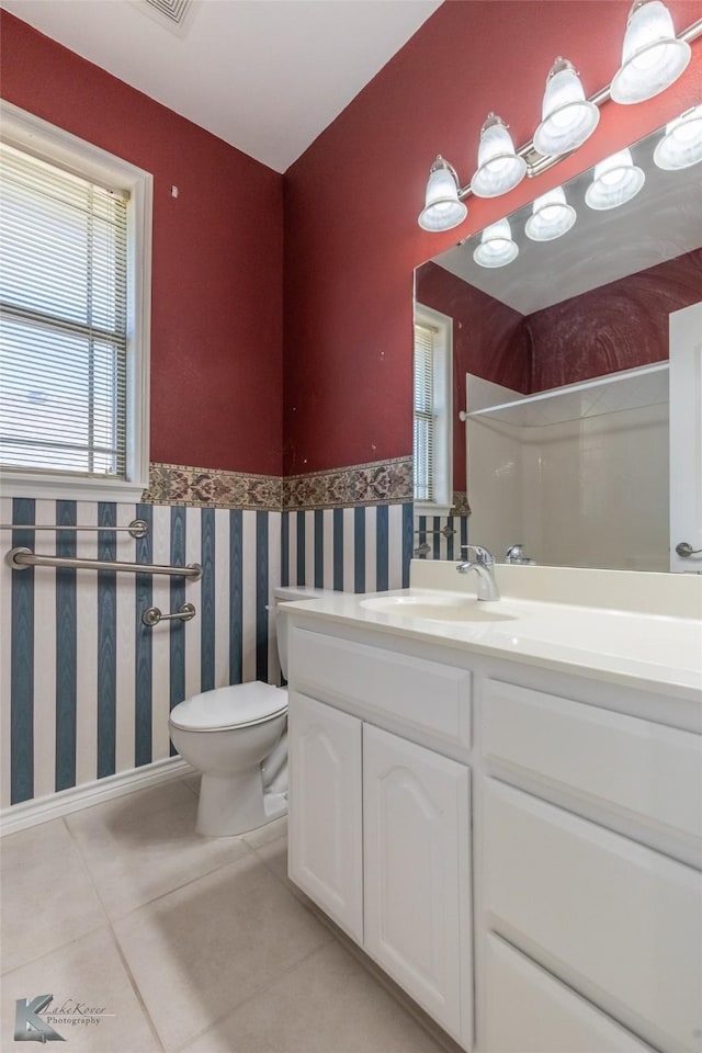 7118 Sable Cir, Abilene, TX 79606 - bathroom featuring tile patterned floors, toilet, vanity, and a wainscoted wall