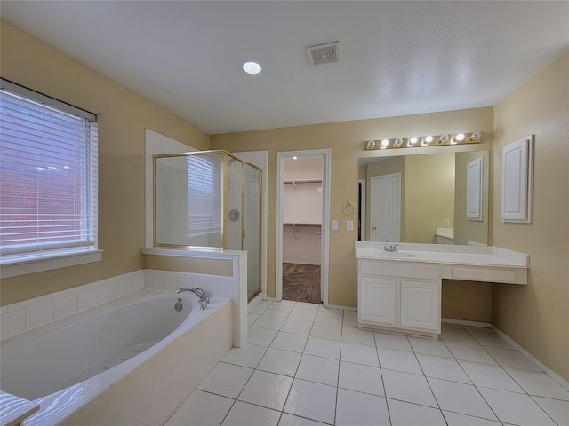 1006 Redwood Trl, Rockwall, TX 75087 - full bathroom featuring a stall shower, tile patterned floors, a garden tub, vanity, and a walk in closet