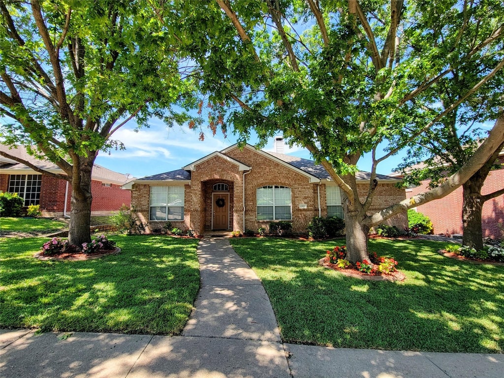 1006 Redwood Trl, Rockwall, TX 75087 - view of front of home featuring brick siding, a front yard, and a chimney