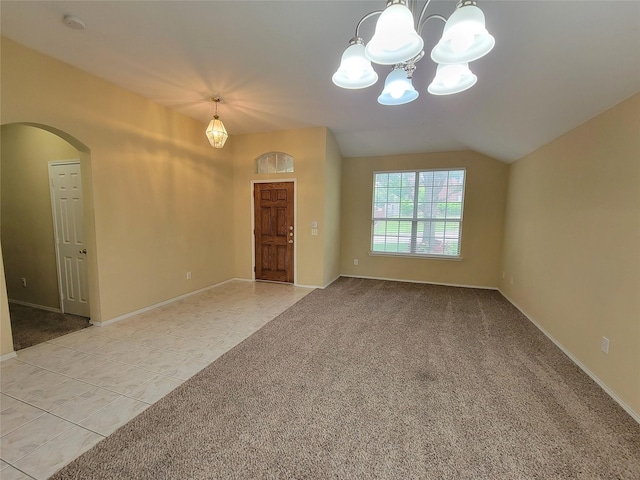 1006 Redwood Trl, Rockwall, TX 75087 - spare room featuring arched walkways, a chandelier, light colored carpet, light tile patterned flooring, and vaulted ceiling