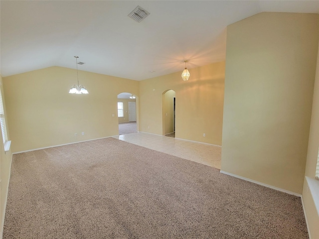 1006 Redwood Trl, Rockwall, TX 75087 - empty room featuring arched walkways, vaulted ceiling, light carpet, baseboards, and a chandelier