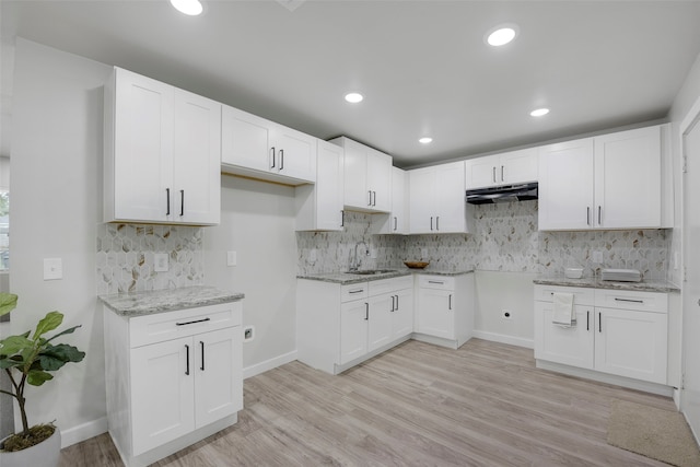 3030 Utah Ave, Dallas, TX 75216 - kitchen featuring under cabinet range hood, light stone countertops, decorative backsplash, light wood finished floors, and recessed lighting