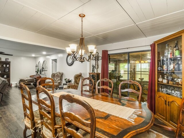dining space featuring dark wood-type flooring, a chandelier, and wood ceiling