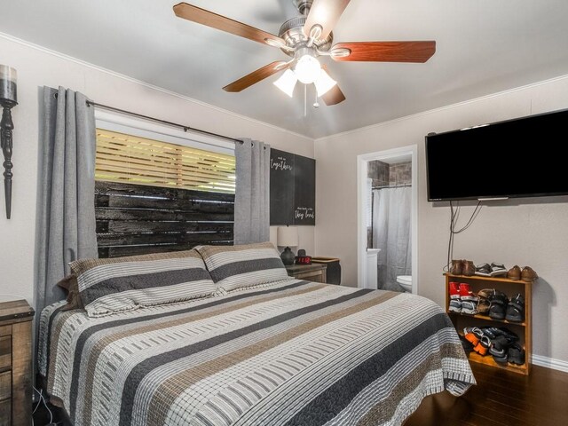 bedroom featuring wood finished floors, baseboards, ceiling fan, ensuite bath, and ornamental molding