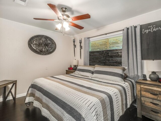 bedroom with baseboards, wood finished floors, ornamental molding, and a ceiling fan