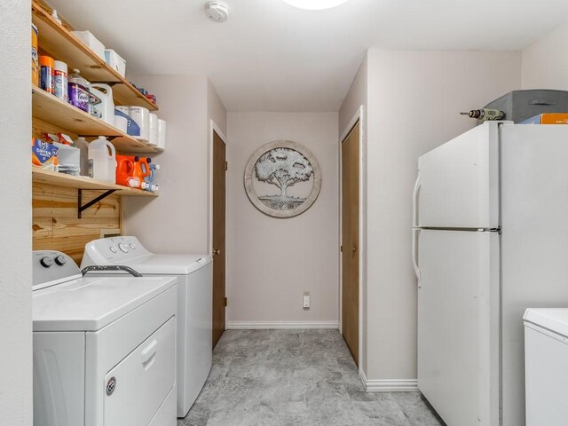 clothes washing area featuring washing machine and dryer and baseboards