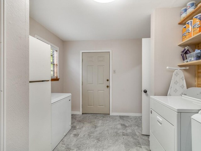 laundry area with washing machine and dryer and baseboards