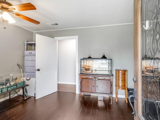 foyer entrance with a ceiling fan, dark wood-type flooring, crown molding, and baseboards