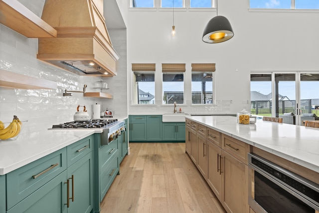 1914 Mann Pkwy, Celina, TX 75009 - kitchen featuring green cabinets, built in microwave, stainless steel gas cooktop, custom exhaust hood, and a towering ceiling