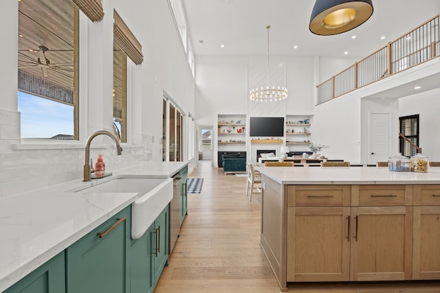 1914 Mann Pkwy, Celina, TX 75009 - kitchen with a high ceiling, open floor plan, a sink, a chandelier, and light stone counters