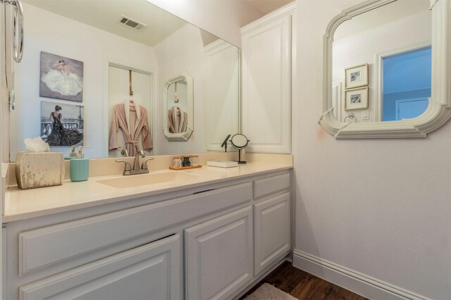bathroom featuring vanity, wood finished floors, and baseboards