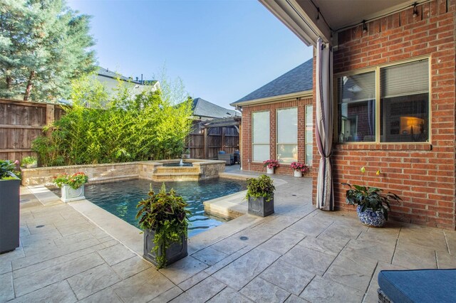 view of swimming pool with a patio area, a fenced backyard, and a pool with connected hot tub